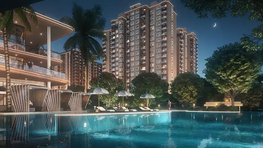 Sattva City clubhouse pool deck at night with lit towers behind